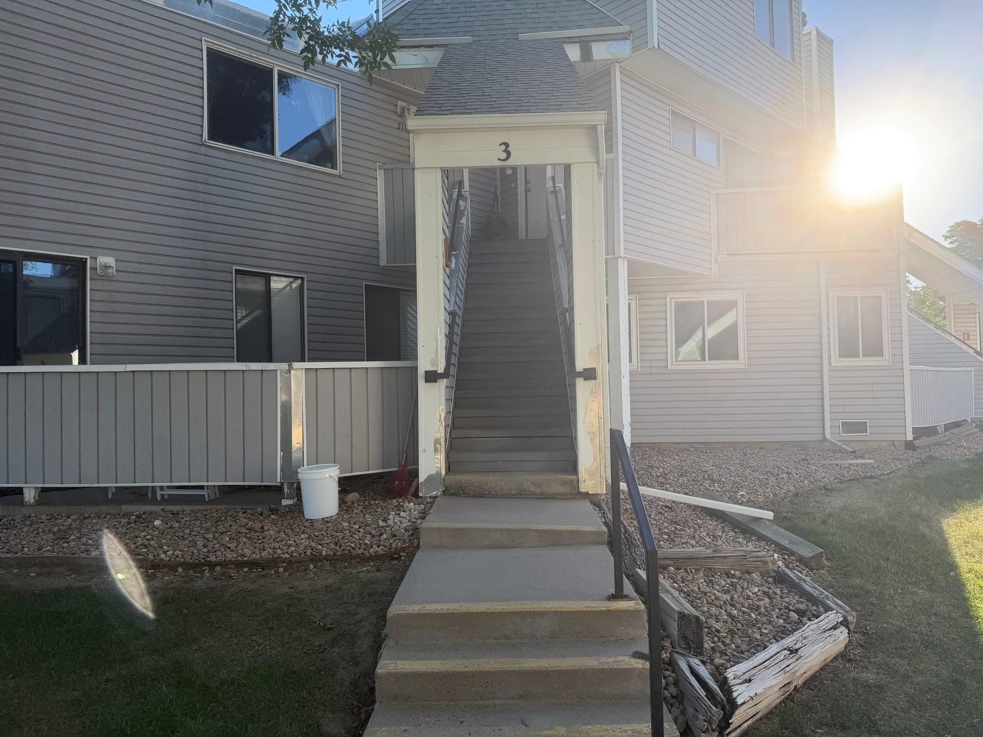 Entry stairs and railing approach — IMG_1052: June 2026 condition photo showing entry stairs, railing, and elevated walkway/deck conditions at a unit approach.