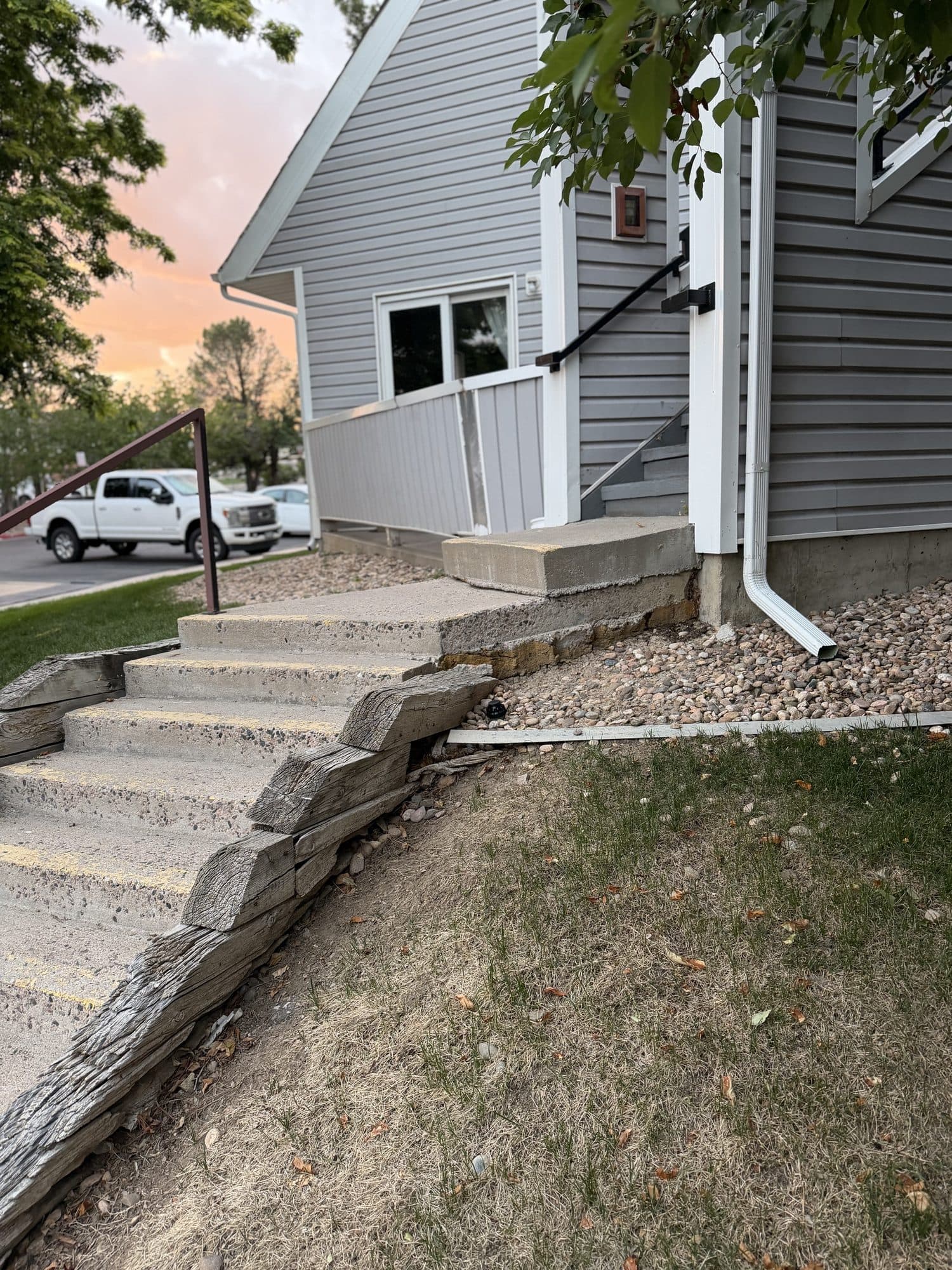 Concrete entry stairs — IMG_1058: Concrete entry stairway on a sloped grade with an adjacent downspout.