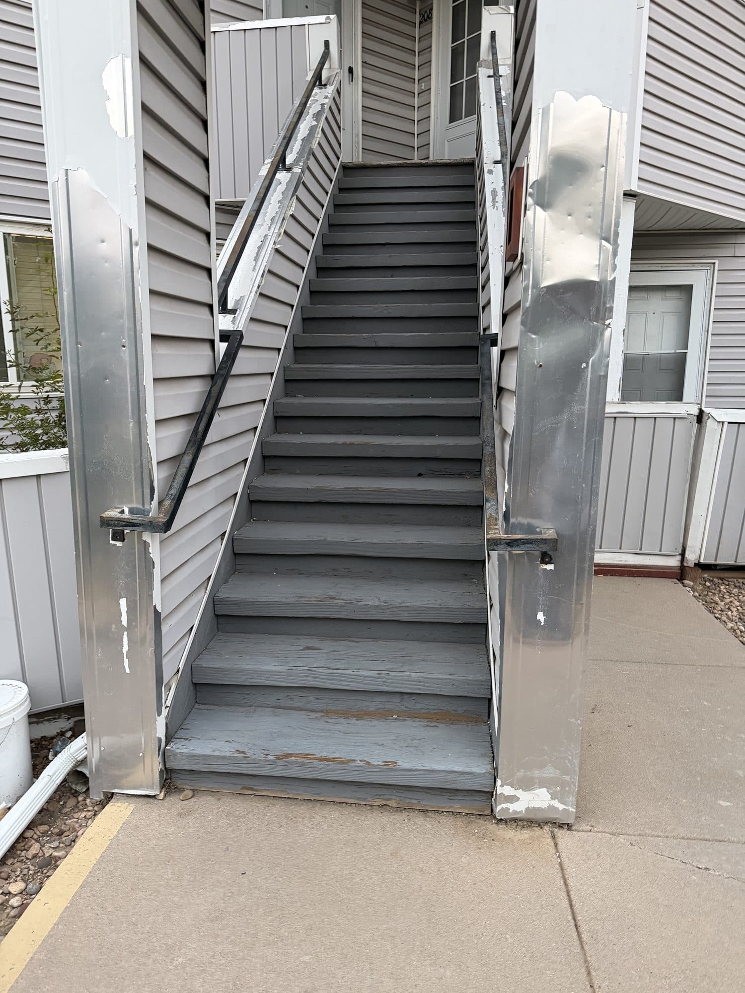 Exterior stairway between buildings — IMG_1068: Concrete-and-metal stairway with handrails between buildings.