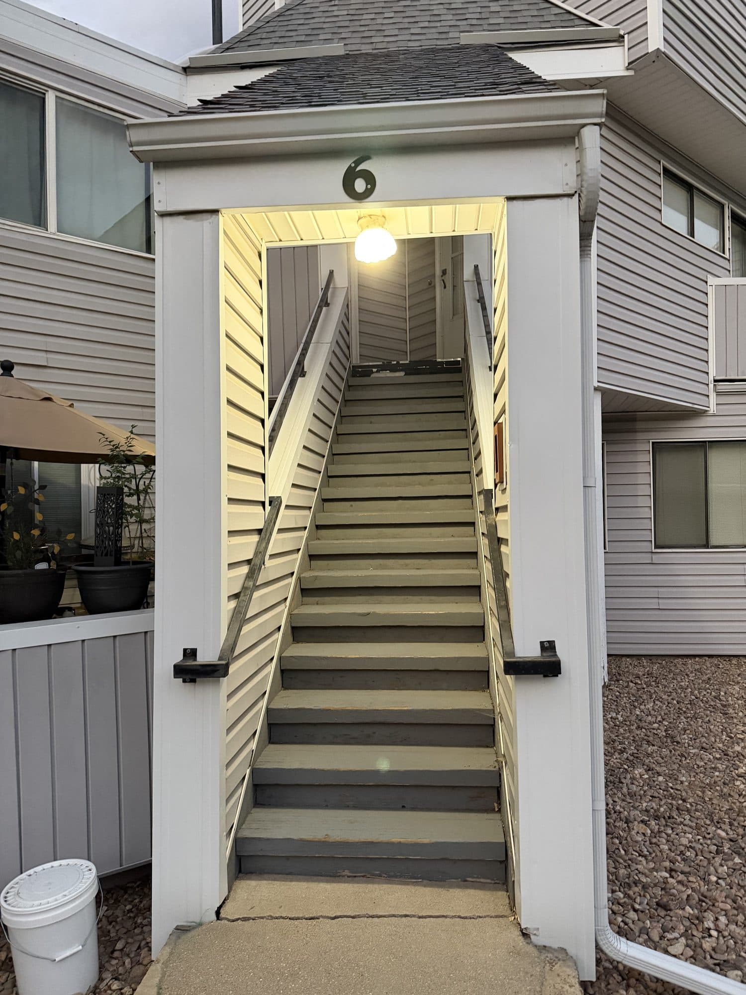 Stairway to unit 6 — IMG_1088: Exterior stairway to unit 6 with metal handrails and gray treads.