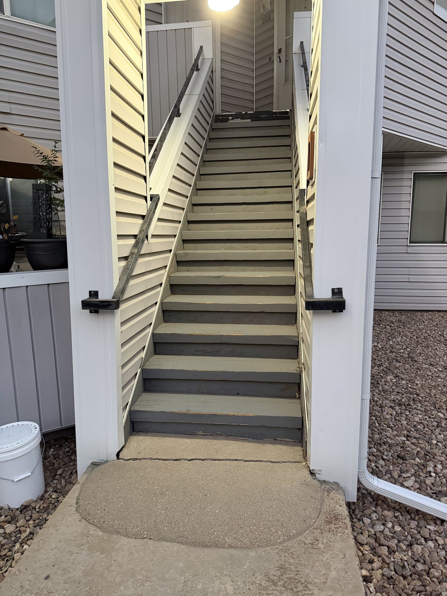 Exterior stairway with caution marking — IMG_1089: Exterior stairway with a painted caution edge and metal handrails.