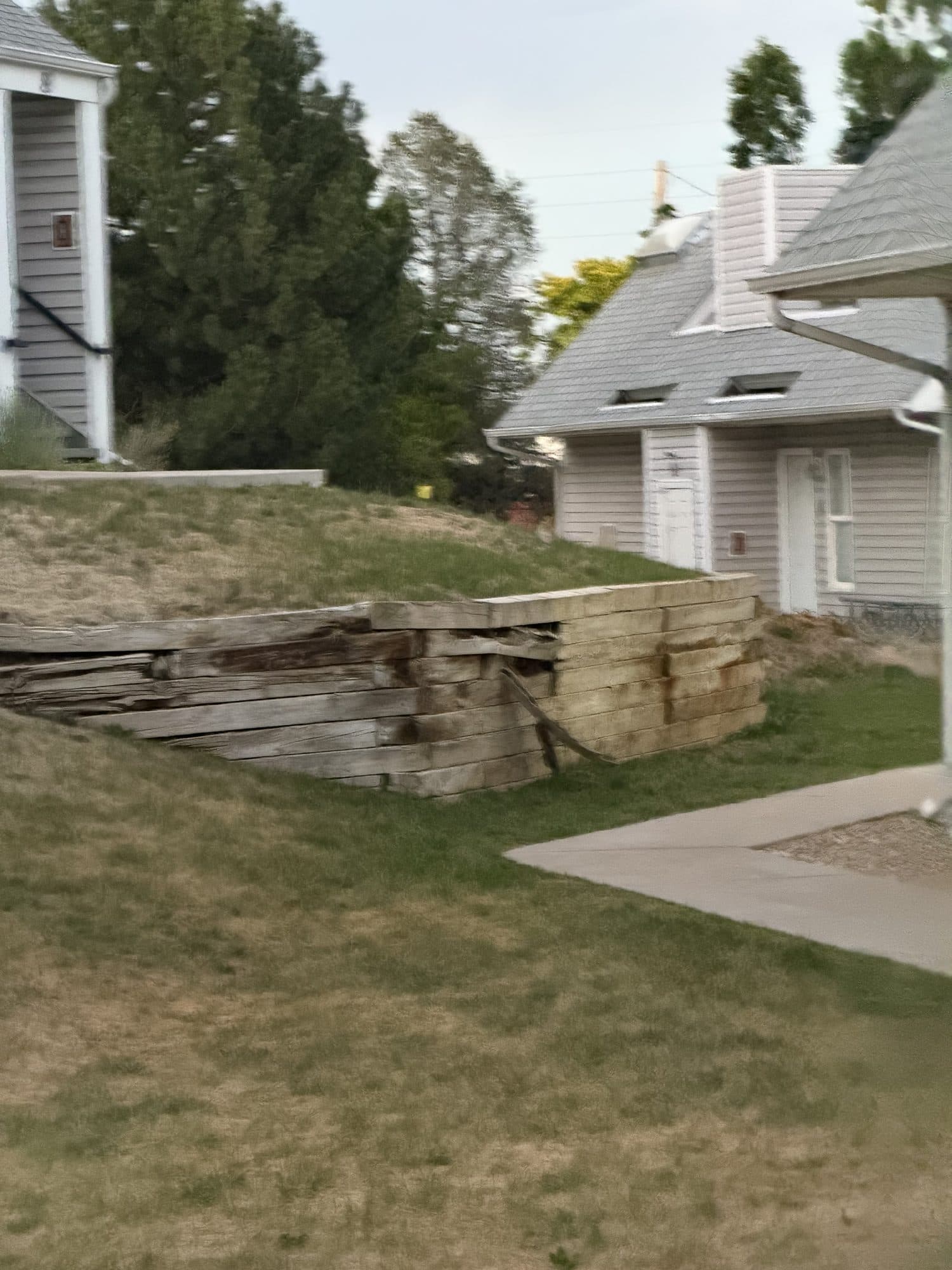 Grounds with low retaining wall — IMG_1090: Building grounds with a low landscape retaining wall and bare lawn.
